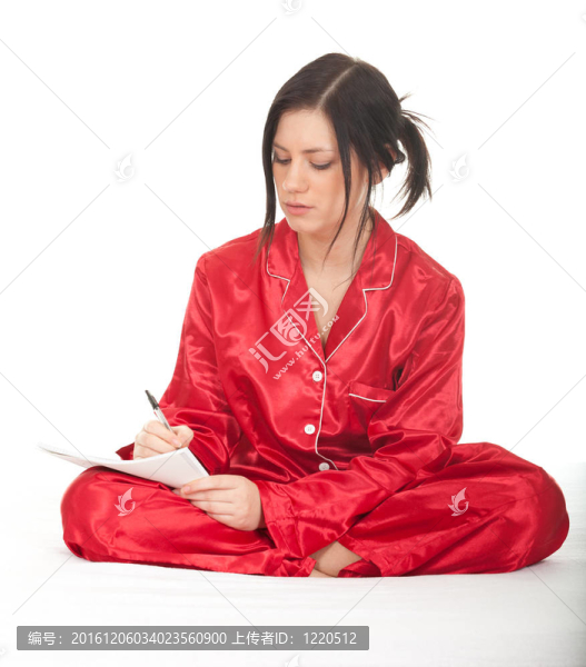 年輕女子穿著紅色睡衣盤腿坐著