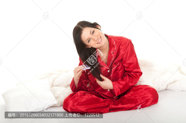 梳著交叉雙腿的紅色睡衣的年輕女子