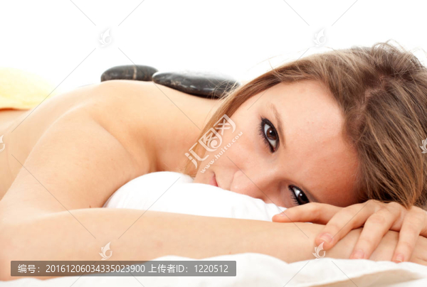 美麗的年輕女子在水療院；石頭按摩