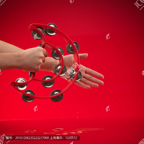 手中握著的紅色背景上的手鼓