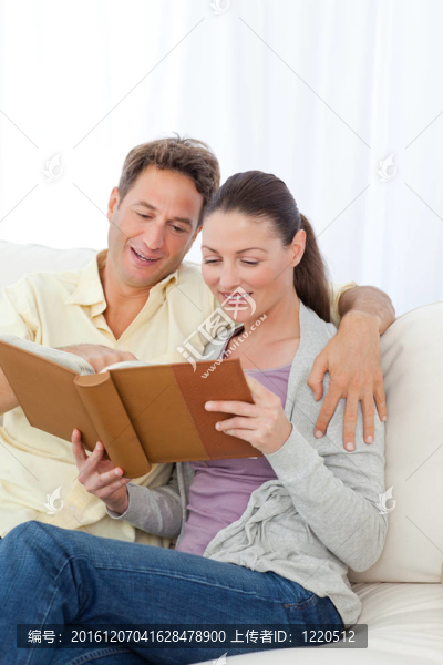 可愛的情侶在沙發(fā)上看相冊(cè)