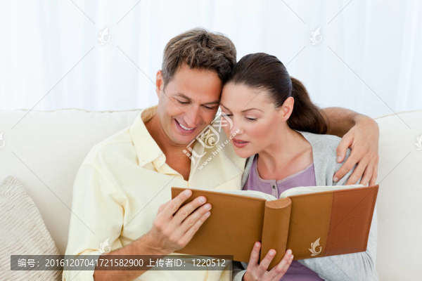 細(xì)心的男人和女人在沙發(fā)上看相冊(cè)