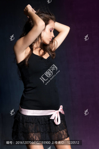 在迪斯科舞廳跳舞的年輕女孩。藍(lán)紫色背景。