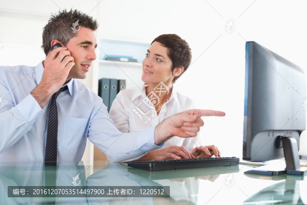 靠近一個男人表現出他的同事在白色背景下的計算機