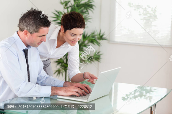 商人指著辦公室里的電腦給她同事的東西