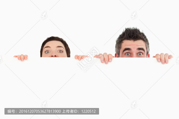 男人和女人躲在一個(gè)白色背景的復(fù)制空間后面