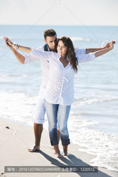 快樂的年輕夫婦在美麗的海灘上玩得開心