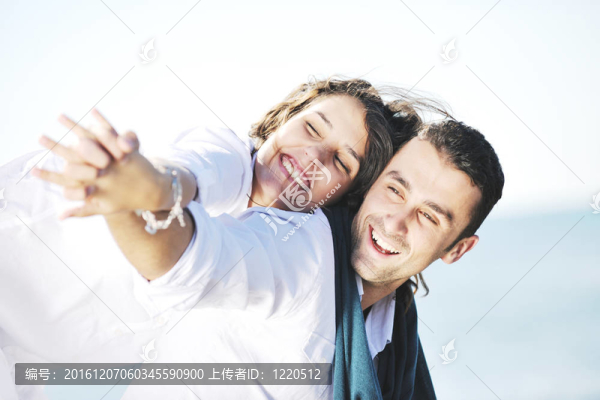 快樂的年輕夫婦在美麗的海灘上玩得開心