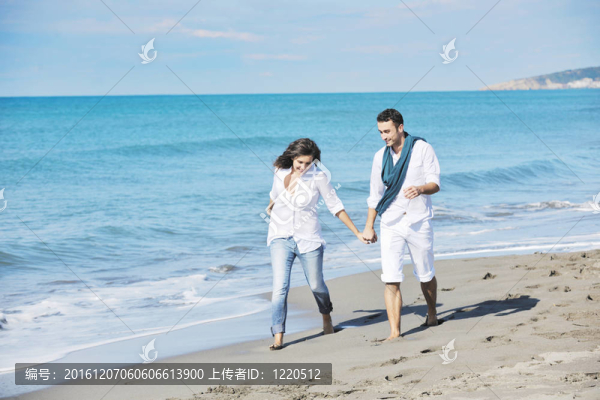快樂的年輕夫婦在美麗的海灘上玩得開心