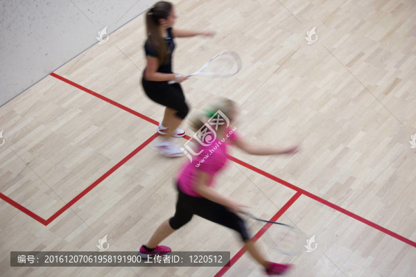 兩名女壁球運動員在壁球場快速動作