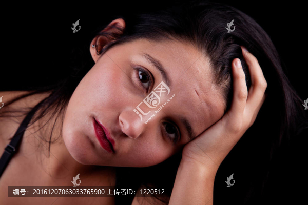 體貼而悲傷的漂亮女人；黑色背景下的孤獨。工作室拍攝。