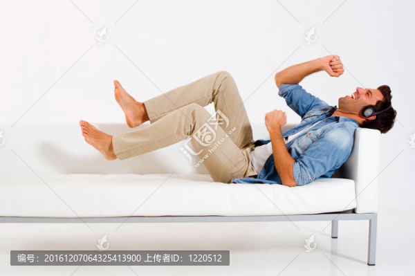男子在沙發(fā)上聽音樂伴耳機