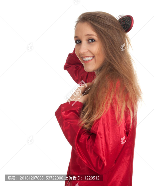 微笑著梳著紅色睡衣的女人梳頭發(fā)