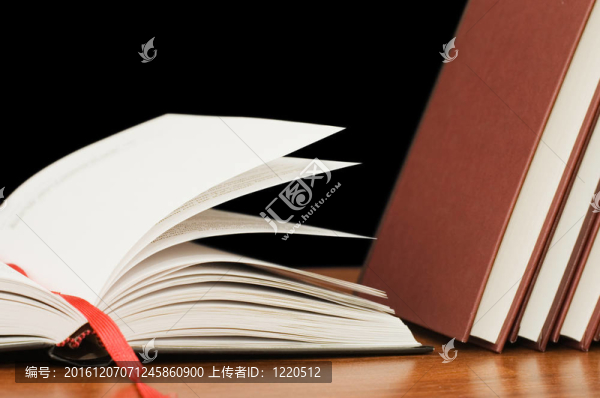 黑色背景上木制桌子上的書