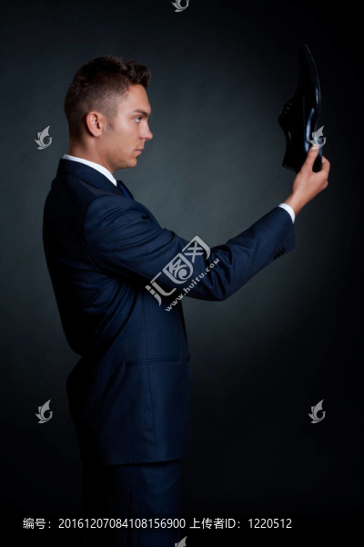 男子穿著優(yōu)雅的西裝和鞋子在手