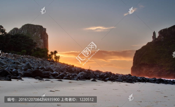 日出的海灘與巖石和懸崖云景觀