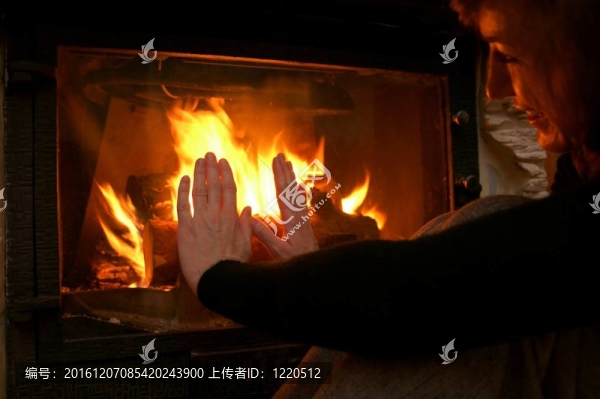 女人暖手在壁爐