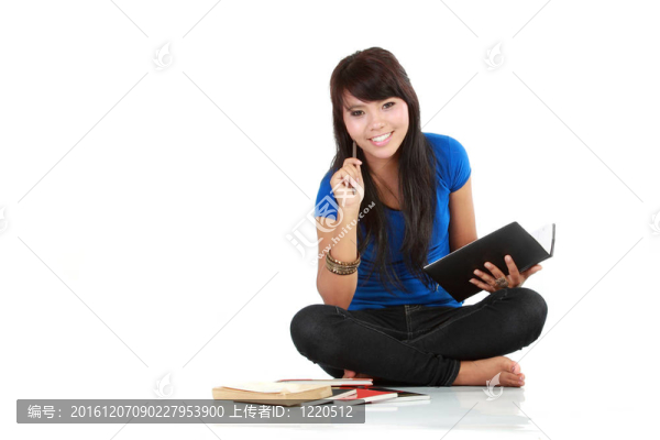 亞洲婦女坐著，寫一本書，孤立的背景
