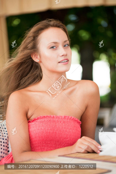 粉紅色的衣服坐在藤椅上的年輕女孩