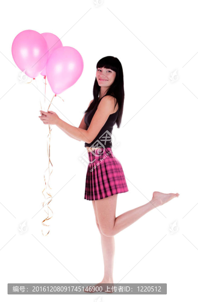 幸福的女人站在一只腿上，手里拿著粉紅色的氣球