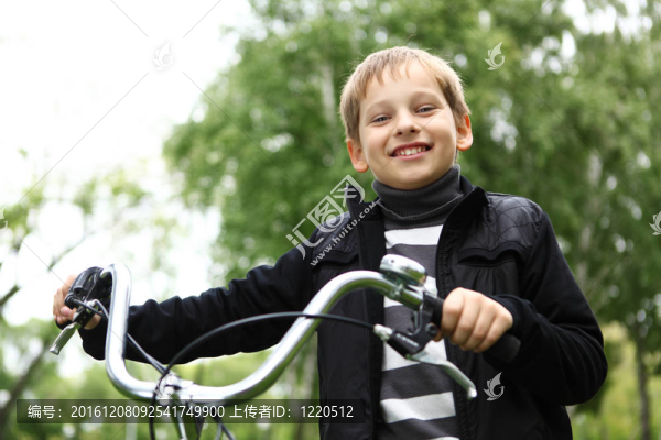 在綠色公園騎自行車的男孩