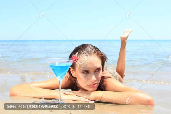 海灘上的年輕女人伴著雞尾酒