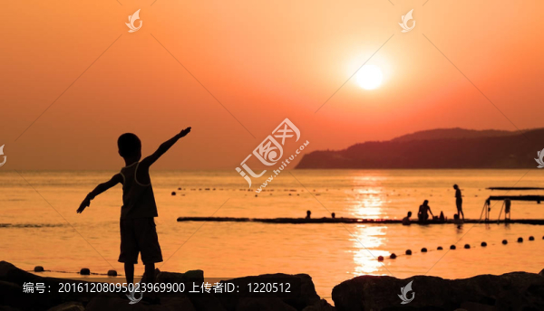 孩子在海上曬橘色夕陽的剪影，攤開雙手