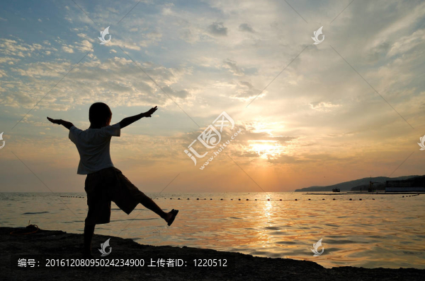 孩子在海上日落的剪影