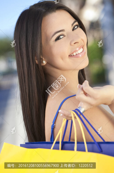 美麗的快樂西班牙婦女與購物袋