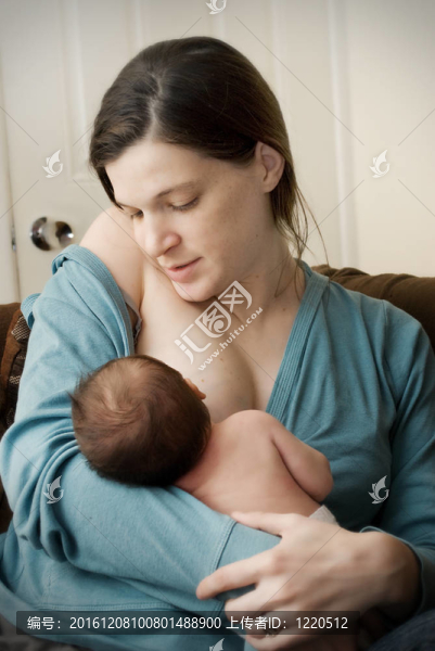 年輕母親喂養(yǎng)新生嬰兒。
