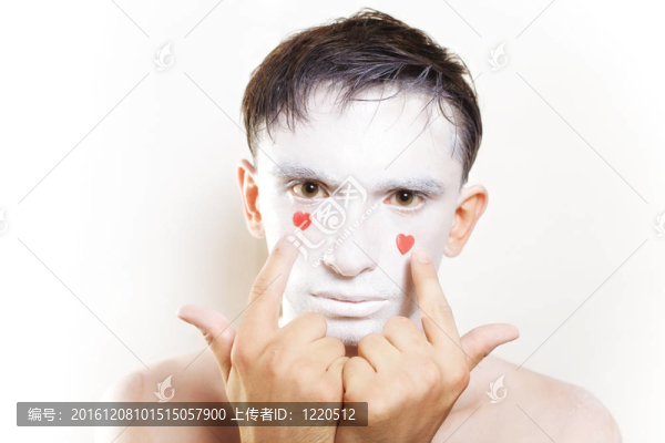 年輕人的臉上有白色的妝和紅色的心
