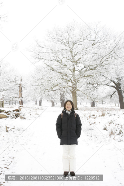 微笑的東亞婦女在白雪覆蓋的里士滿公園