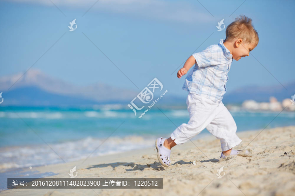 可愛的男孩在美麗的海灘上快樂地玩耍