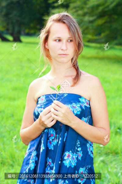 一個穿著藍色衣服的年輕女人手里拿著一棵小植物