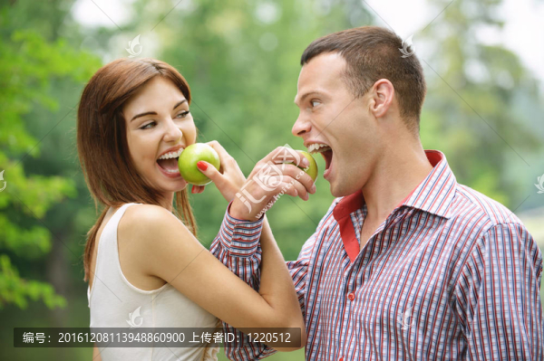 兩個年輕快樂的人吃蘋果