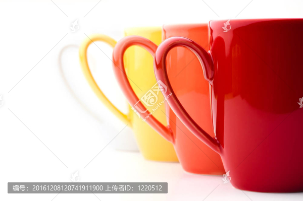 明亮多彩的馬克杯看行；紅；橙；黃的、白的；在白色的背景