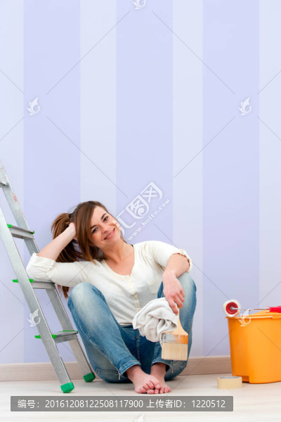 年輕的女人坐在地板上畫好后。