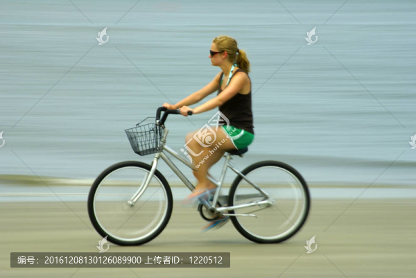 在海灘上騎自行車的女孩