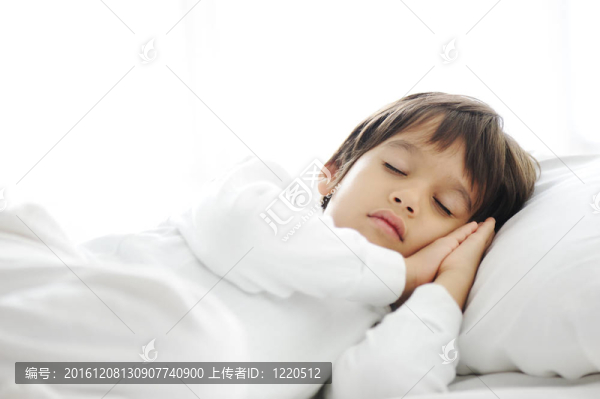 睡在床上的孩子；白色臥室里快樂的就寢時(shí)間