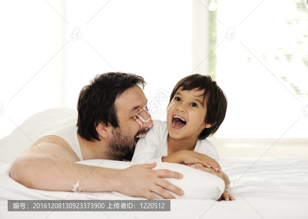 父親和兒子在床上；快樂時光