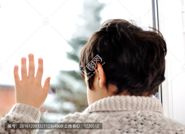 悲傷的孩子在窗外，冬天的雪在外面