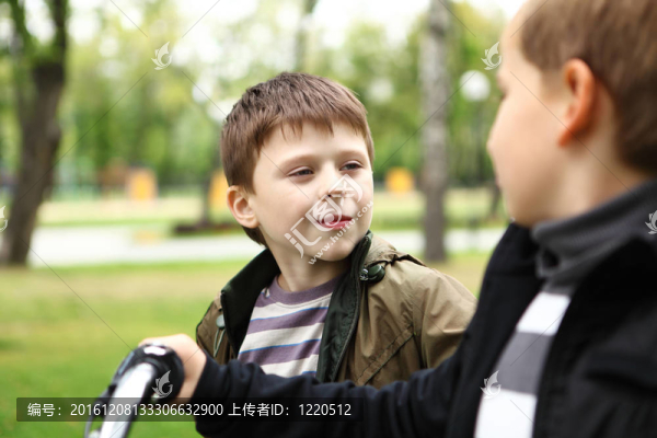 在綠色公園騎自行車的男孩