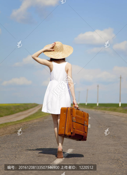 鄉(xiāng)村路上帶著手提箱的寂寞女孩。