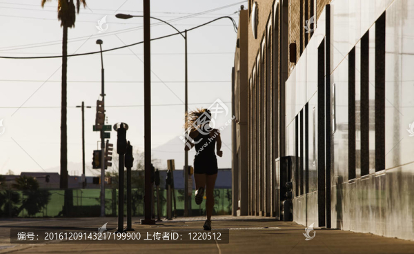 早晨，一個(gè)女人在城市街區(qū)奔跑。