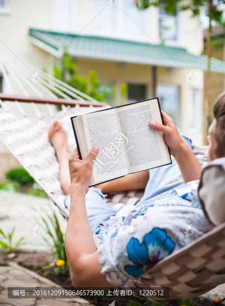 男人擺inhammock看書