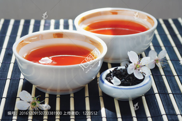 兩杯茶；一罐茶葉和櫻花在竹桌布上靜物