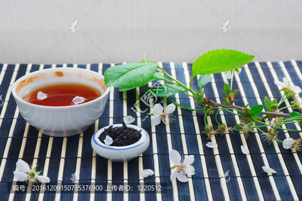 一杯茶；一罐茶葉和櫻花，竹葉上的桌布依然活著