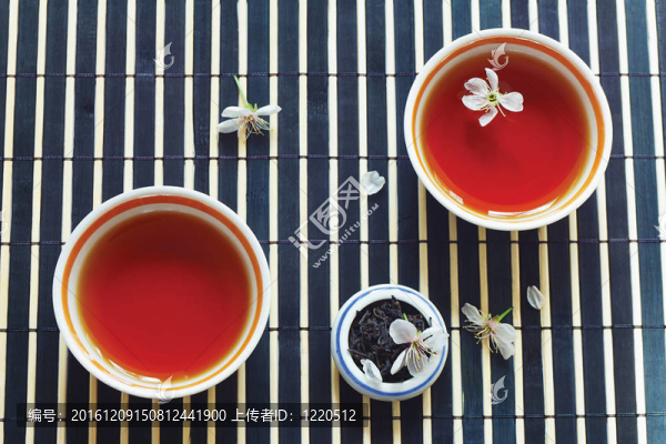 兩杯茶；一罐茶葉和櫻花在竹桌布上靜物