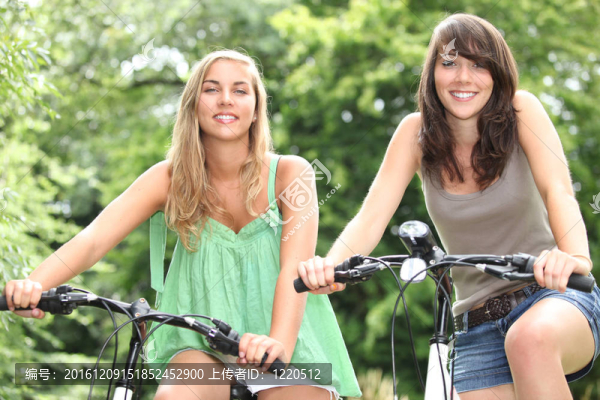 兩個十幾歲的女孩在鄉(xiāng)下騎自行車
