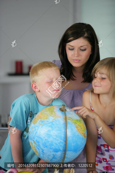 女人和孩子在看地球儀